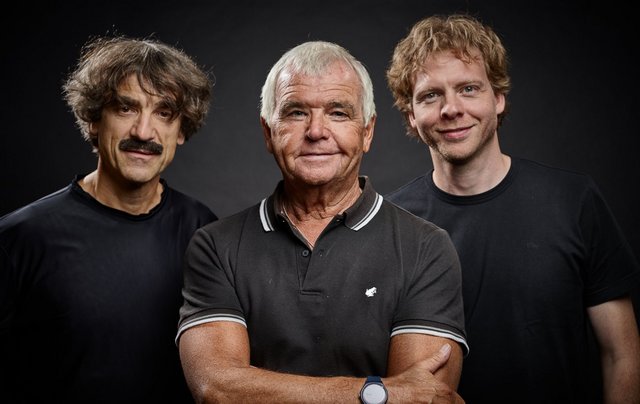 Drei Männer schauen in die Kamera