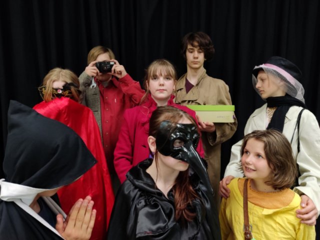 Mehrere junge Menschen verkleidet vor schwarzem Hintergrund